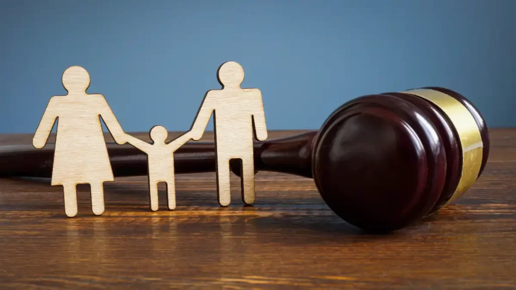 a wooden gavel on a wooden table with a wooden family and a gavel in front of it