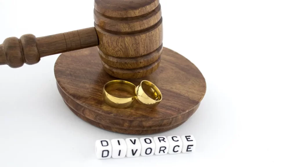 wedding rings on a wooden gavel with the word divorce in front of it