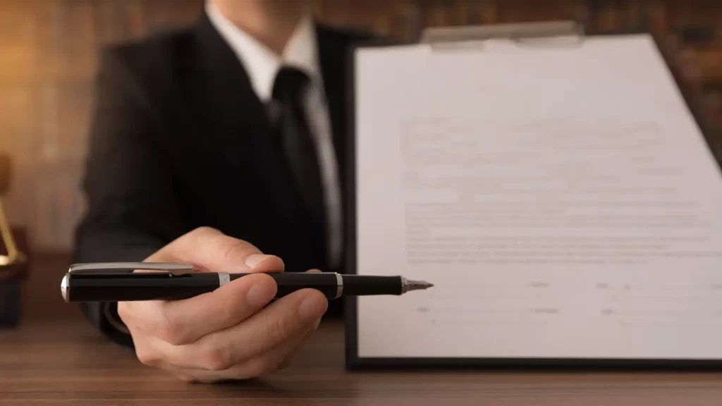 a lawyer holding a pen in front of a piece of paper